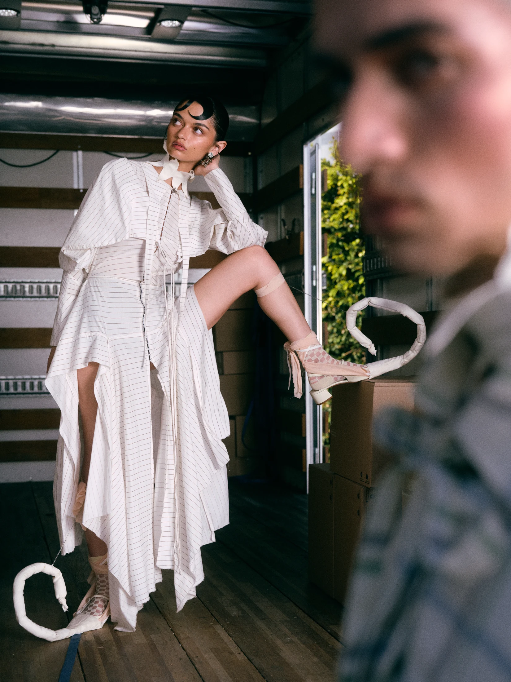 Fashion portrait inside a truck with a softly blurred foreground figure